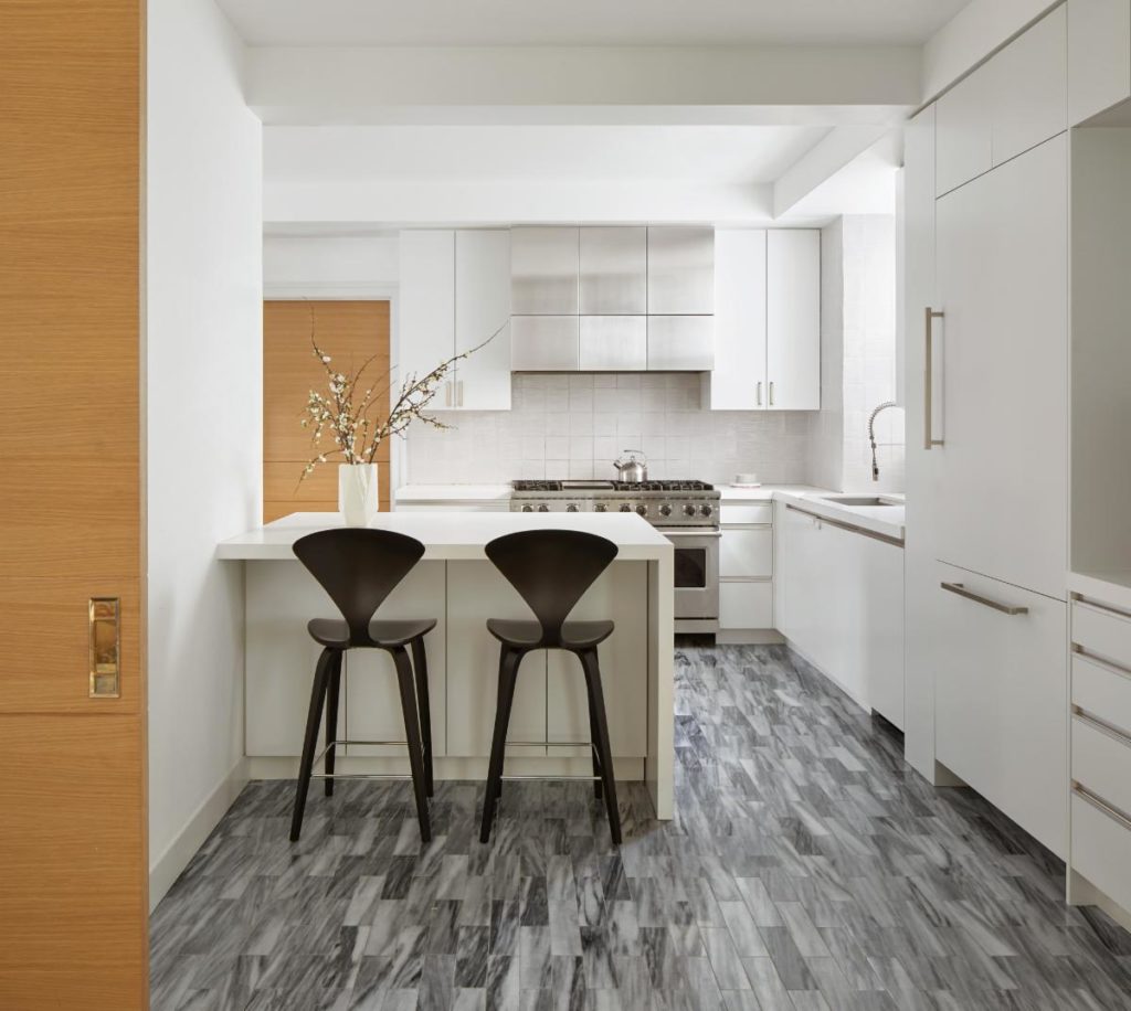 The kitchen was completely reworked. A new, expanded layout gave way to a new peninsula, custom cabinetry, marble floors, and custom designed stainless steel hood. Photo: Gieves Anderson